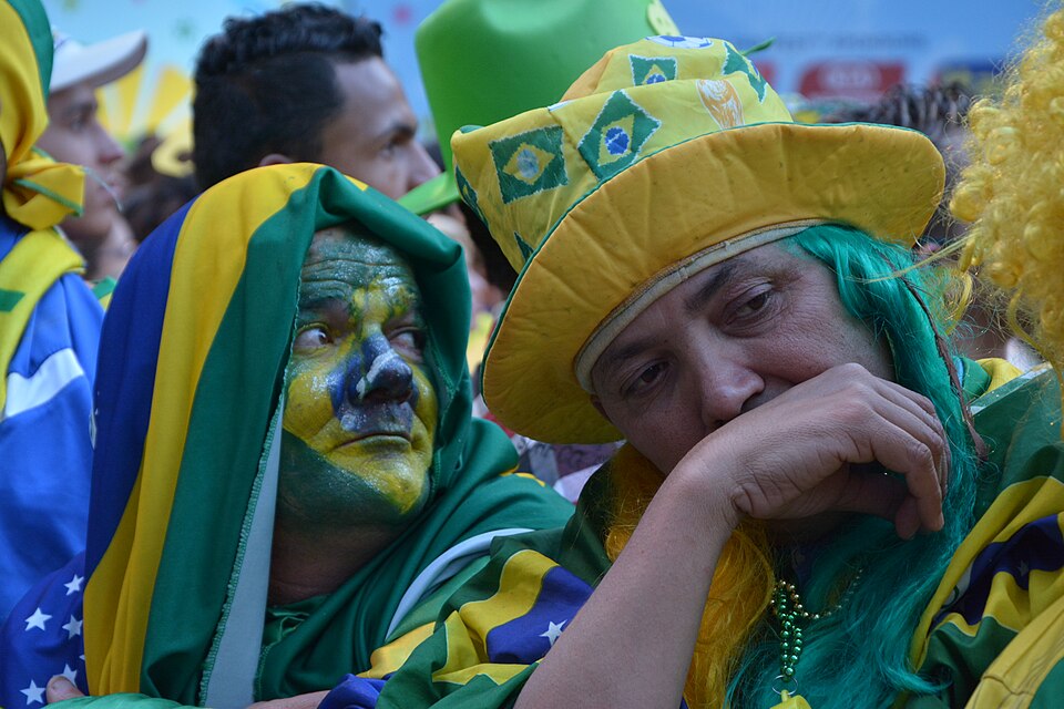 Hinchas observando un partido de fútbol con tensión en las tribunas