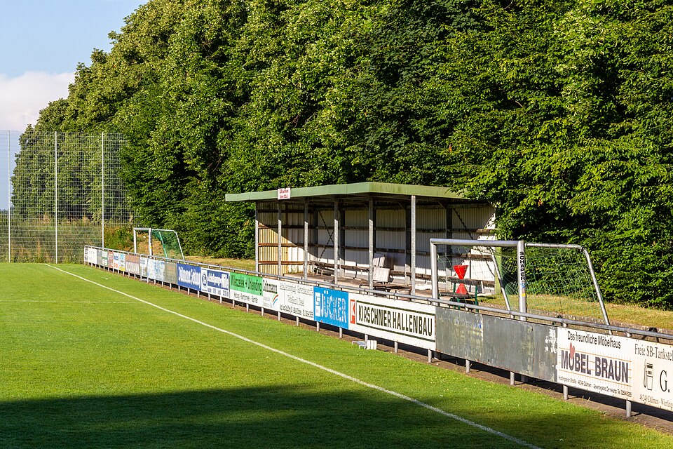Hinchas siguiendo cuotas y partido en una pantalla grande