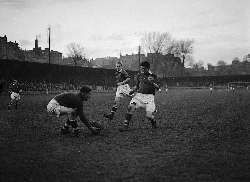 Hinchas siguiendo un partido europeo en un bar deportivo