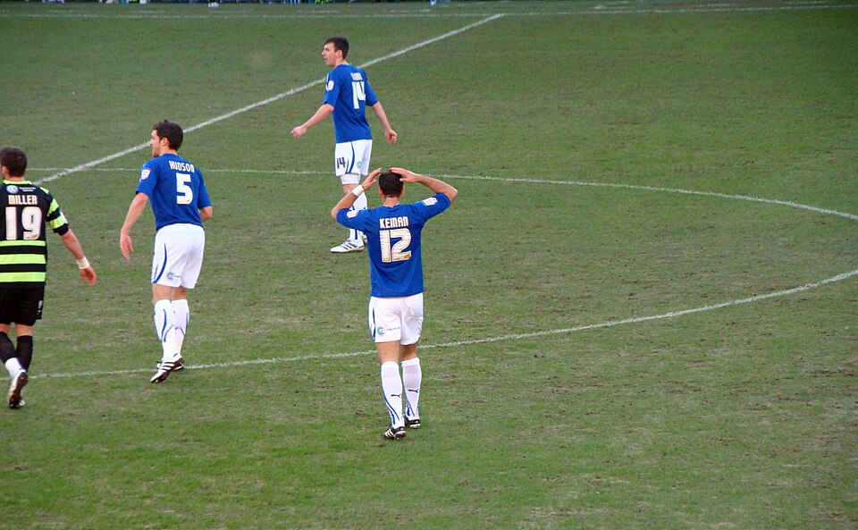 Estadio andino con tribunas llenas durante un partido nocturno