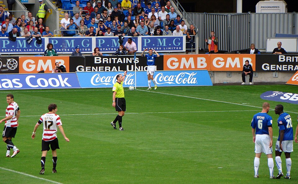 Hinchas mirando un partido y revisando cuotas en un bar