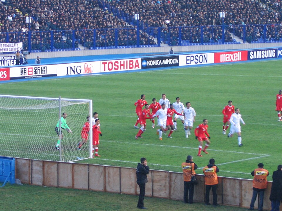 Jugador ejecutando un saque de esquina en un estadio argentino